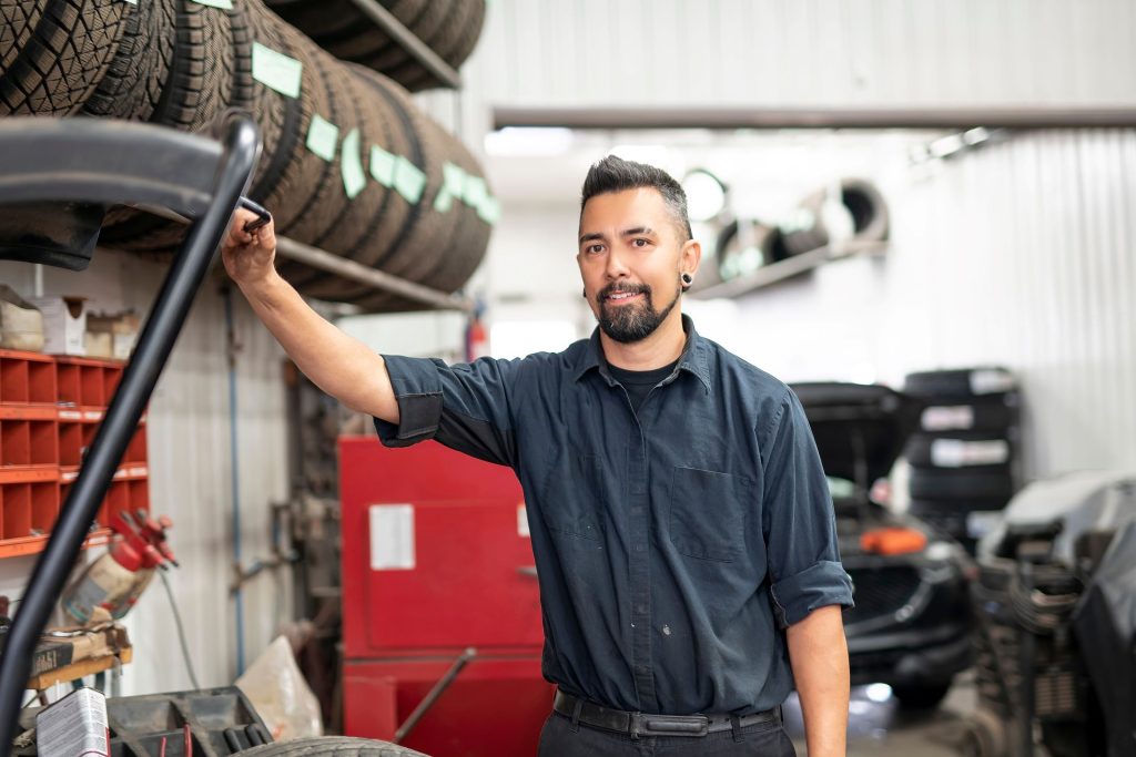 Deisel truck technician, male, standing in mecahnic garage.
